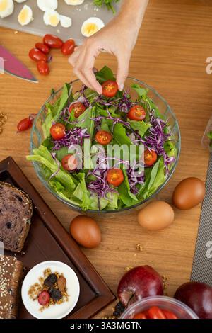 Ein wunderschöner, frischer Salat mit knusprigem Salat, süßen Kirschtomaten und lebendigem Rotkohl, perfekt in einer Schüssel angeordnet, bereit zum Genießen Stockfoto