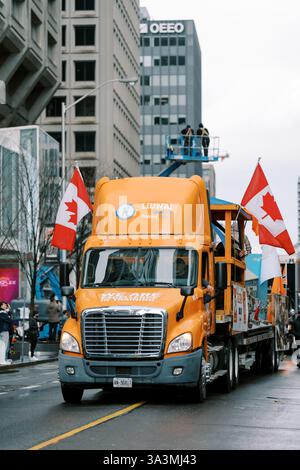 Kanada, Toronto - 16. märz 2025: Saint Patrick Day Parade. Lebhafte Parade mit orangefarbenem Truck mit kanadischer Flagge Stockfoto