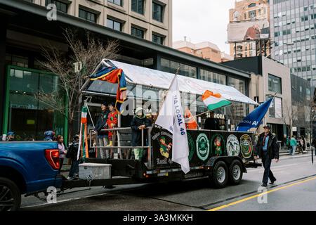 Kanada, Toronto - 16. märz 2025: Saint Patrick Day Parade. Stadtparade mit bunten Flaggen auf einem festlichen Schwimmer Stockfoto