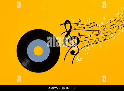 Schwarze Schallplatte, die einen Musikstrom auf gelbem Hintergrund abspielt und musikalischen Genuss darstellt Stockfoto
