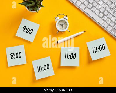 Haftnotizen mit einem Arbeitsplan von 8 bis 12, Wecker, Stift und Tastatur auf gelbem Hintergrund. Zeitplan, Erinnerung und Planung Co Stockfoto