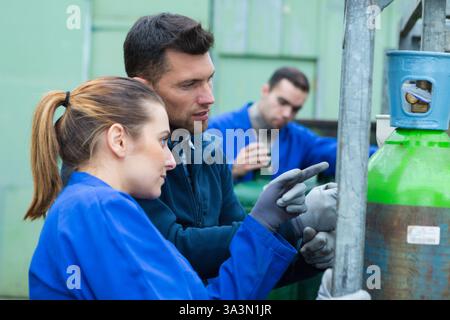 Arbeiter mit Tanks für die Industrie außerhalb der Fabrik Stockfoto
