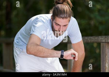 Smartwatch Runner man überprüft den Fortschritt auf der Smart Fitness Sportuhr Stockfoto