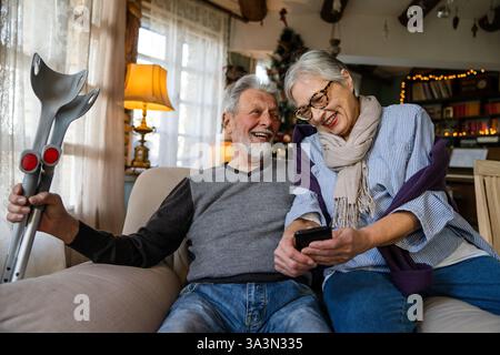 Glückliche Freundschaft mit älteren verheirateten Paaren, die sich entspannen, lachen und die gemeinsame Freizeit zu Hause genießen. Stockfoto