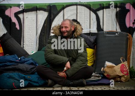 Frankfurt am Main, Deutschland. März 2025. Ein Porträt eines Obdachlosen auf der Brücke. Stockfoto