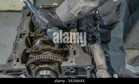 Automechaniker arbeitet am Automotor in der Mechanikerwerkstatt. Reparaturservice. Professioneller Mechaniker, der in der Garage am Motor des Autos arbeitet. Autoreparatur Stockfoto