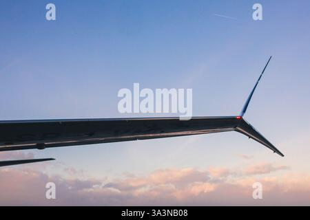 Nahaufnahme des Flugzeugflügels gegen den Abendhimmel Stockfoto