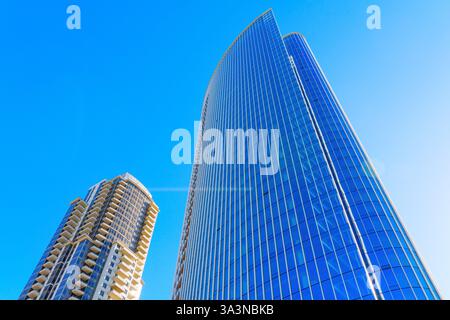 San Diego, Kalifornien - 14. Januar 2025: Zwei moderne Wolkenkratzer, die sich in Richtung eines klaren blauen Himmels in San Diego, Kalifornien, erheben den Architekten hervor Stockfoto