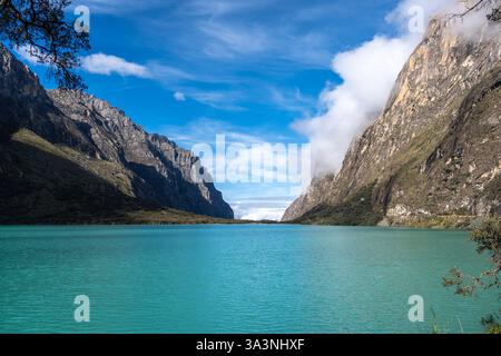 Ein atemberaubender türkisfarbener See reflektiert den blauen Himmel, eingebettet zwischen hoch aufragenden Bergen. Die friedliche Landschaft ist Teil der berühmten Laguna 69 Trek in Hu Stockfoto