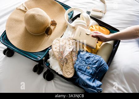 Frau packt für den Sommerurlaub Stockfoto
