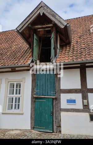 16. März 2025: Neubruchhaussen: Traditionelle Fachwerkwassermühle mit grünen Holztüren, rotem Ziegeldach und Steintreppe nach innen. Stockfoto