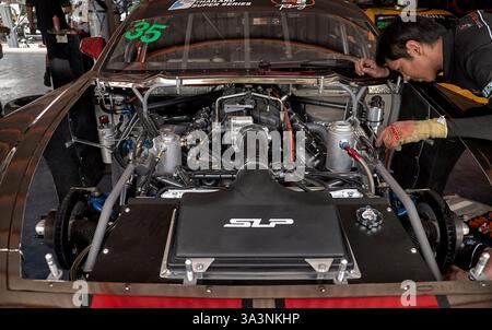 Motormechaniker, der am Motor eines Ford Mustang Rennwagens arbeitet. Bira Circuit, Pattaya, Thailand, Südostasien Stockfoto
