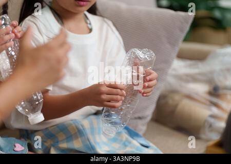 Nachhaltigkeit und Kindererziehung. Kinder führen Recyclingverfahren durch, indem sie Plastikflaschen für die Entsorgung vorbereiten. Stockfoto