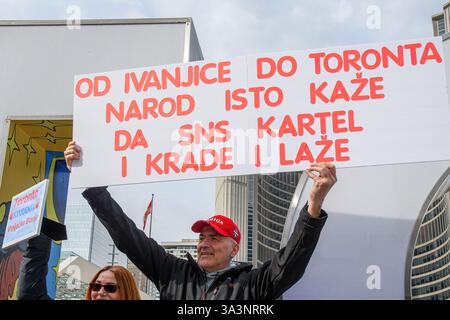 Tiefwinkelansicht eines Mannes mit einem Schild auf dem Nathan Phillips-Platz während eines Protests der serbischen Gemeinschaft zur Unterstützung von Studenten, die gegen das Demonstrieren demonstrieren Stockfoto