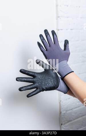 Eine Person trägt ein stylisches Paar schwarze und graue Handschuhe, die ihren Sinn für Mode zum Ausdruck bringen und gleichzeitig ihre Hände gemütlich und geschützt halten Stockfoto