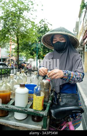 Straßenverkäufer bereiten auf einem Fahrrad in yogyakarta, indonesien, gekonnt Kräutermedizin zu und zeigen die lebendige lokale Kultur und Wellness-Traditionen Stockfoto