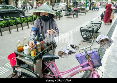 Straßenverkäufer, der Kräutermedizin mit ihrem Fahrrad in yogyakarta, indonesien, zubereitete, traditionelle Heilmittel und lebendige lokale Kultur Stockfoto