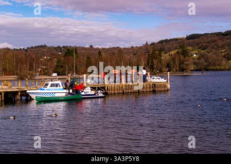 Touristen mieten ein Schnellboot von einem Steg im Coniston Water Lake District National Park Cumbria Stockfoto