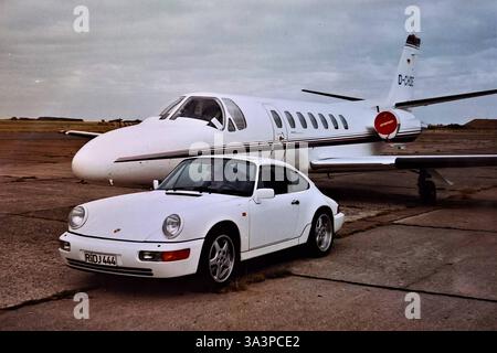 DAS DATENSATZDATUM WURDE NICHT ANGEGEBEN. Sylt, Flughafen Westerland im Jahr 1995. Der Porsche 964 ist ein Sportwagen des Automobilherstellers Porsche. Er ist das Nachfolgemodell des Porsche 911 G-Modell und kam 1989 auf den Markt. Der 964 wurde sowohl mit Heckantrieb als Carrera 2 und mit Allradantrieb als Carrera 4 angeboten. Generell waren für den Porsche 964 Ausstattungen erhältlich, die beim Vorgängermodell nicht angeboten wurden, wie zum Beispiel Servolenkung und ABS bzw Antiblockiersystem. Die Motorleistung des 964 reicht von 184 kW bzw 250 PS bei den Carrera-Modellen und bis zu 265 kW bzw 360 PS bei Stockfoto