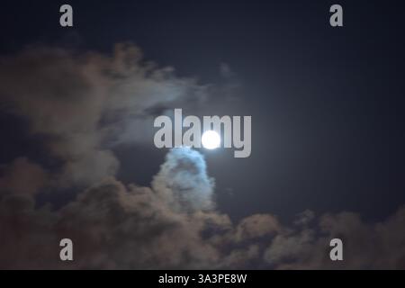 Teilweise bewölkter Himmel mit Vollmond in der Nacht. Leuchtender Vollmond. Stockfoto