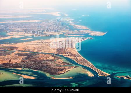 Atemberaubende Luftperspektive mit Blick auf Abu Dhabis moderne Skyline, künstliche Inseln und pulsierende Küste Stockfoto