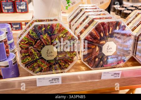 23. Januar 2025, Abu Dhabi, VAE: Köstliche Datteln und Pistazien in einer achteckigen, transparenten Kunststoffbox, die in einem Ladenregal zum Kauf bereit ist Stockfoto