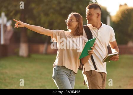 Etwas mit dem Finger zeigen. Zwei Studenten sind draußen. Stockfoto