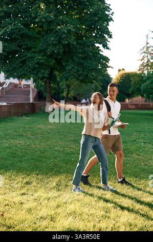Etwas mit dem Finger zeigen. Zwei Studenten sind draußen. Stockfoto