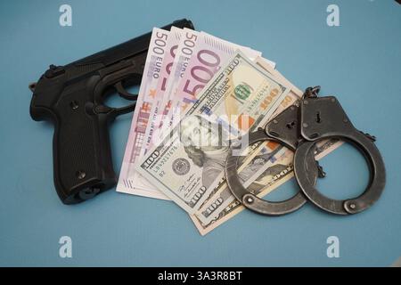 Euro- und Dollarscheine mit Pistole auf dem Tisch. Stockfoto