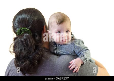 Frau, die ihren Jungen vor weißem Hintergrund hält Stockfoto