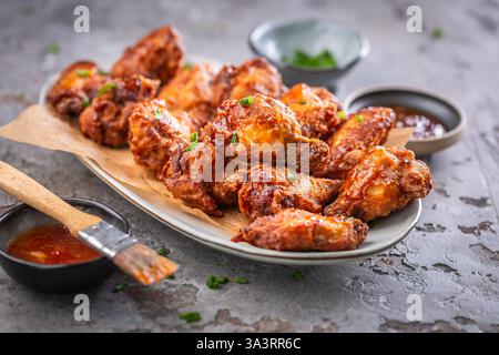Scharfe thailändische Hähnchenflügel mit heißem Dip und grünen Zwiebeln Stockfoto