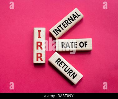 IRR - Internal Rate of Return symbol. Concept word IRR on wooden cubes. Beautiful red background. Business and IRR concept. Copy space. Stockfoto