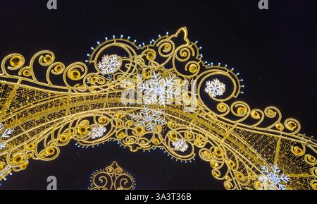 Wunderschöne glühende Weihnachten- und Neujahrsdekoration mit Schneeflocken auf der Abendstraße Stockfoto