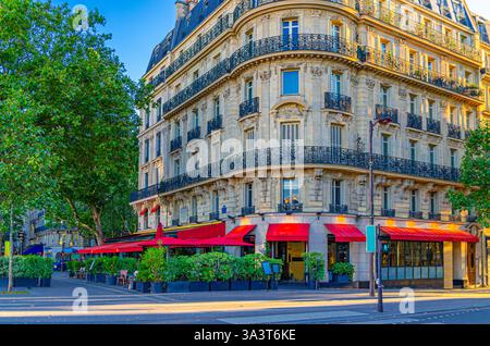Paris City mit Straßencafé Restaurant am Boulevard, traditionelles Pariser Architektur Apartmentgebäude mit typischer Fassade, Balkonen und Fenstern i Stockfoto