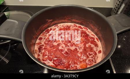 Topf mit kochenden Erdbeeren, um hausgemachte Marmelade zu machen Stockfoto
