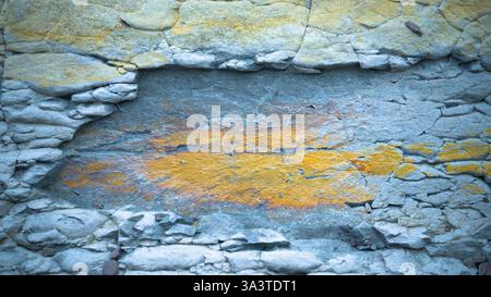 Nahaufnahme einer strukturierten Gesteinsoberfläche mit Schichten von gerissenem Stein. Stockfoto