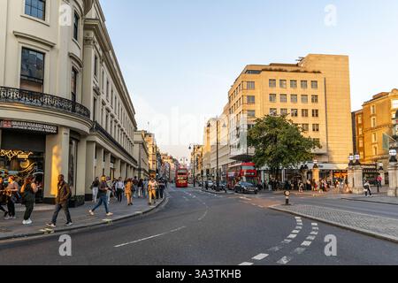 London, Großbritannien - 19. September 2024: London s Strand im Abendlicht: Berühmte Busse passieren die historische West Strand Architecture. Stockfoto