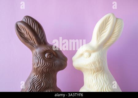 Schokolade in Form von zwei Osterhasen auf rosa Hintergrund. Stockfoto