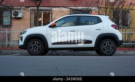 Bukarest, Rumänien – 19. Januar 2025: Seitenansicht des weißen Elektroautos Dacia des rumänischen Herstellers Dacia, geparkt vor einem Wohnblock Stockfoto