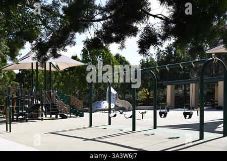 IRVINE, KALIFORNIEN - 10. Februar 2025: Spielplatz im Cypress Community Park mit Schaukeln, Rutschen und Klettergeräten. Stockfoto