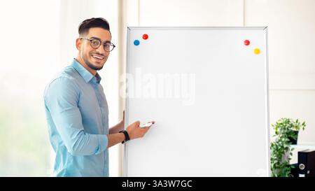 Junger arabischer Geschäftsmann, der sich in einem Firmenbüro präsentiert Stockfoto