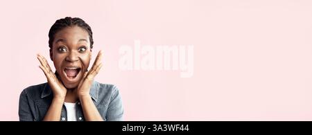 Aufgeregte Frau, die Freude mit Händen auf den Wangen vor rosa Hintergrund zeigt Stockfoto
