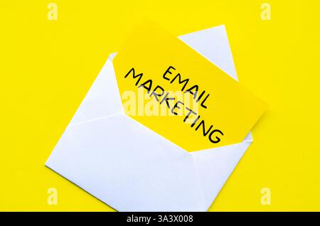 E-Mail-Marketingtext auf gelbem Notizblock in einem weißen Umschlag. Online-Konzept „Geld verdienen“. Stockfoto