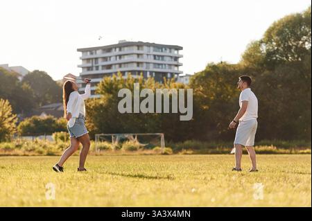 Seitenansicht. Mann mit Frau spielen Badminton auf dem Spielfeld. Stockfoto