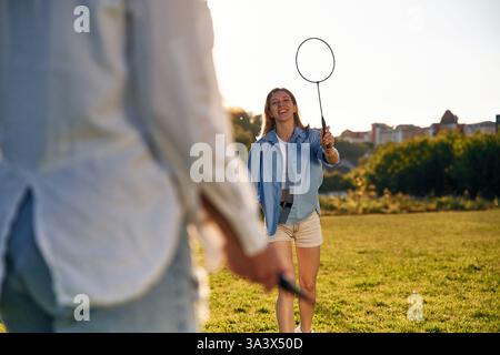In Freizeitkleidung. Zwei Frauen haben Spaß mit Badmintonschlägern auf dem Feld. Stockfoto