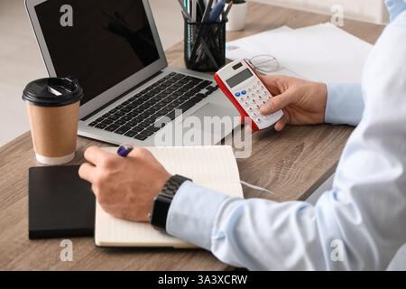 Männliche Hände, die Berechnungen im Büro machen. Nahaufnahme Stockfoto