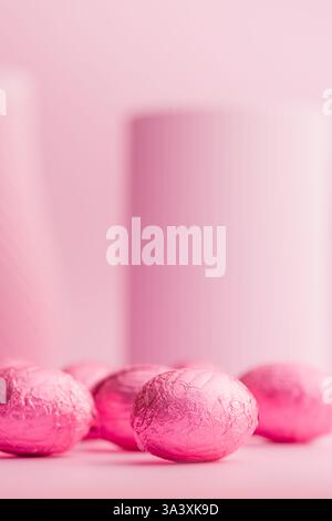 Schokoladen-ostereier in pinkfarbene Folie auf rosa Hintergrund gewickelt. Stockfoto