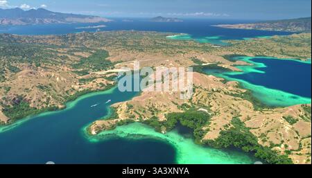 Bei einem atemberaubenden Blick aus der Luft auf den Komodo-Nationalpark in Indonesien zeigt sich türkisfarbenes Wasser mit üppigen Inseln in einem lebendigen Wandteppich der Schönheit der Natur Stockfoto