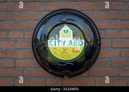 City AED auf einer Steinmauer montiert. Ein AED oder ein automatisierter externer Defibrillator wird verwendet, um Patienten mit plötzlichem Herzstillstand zu helfen. Stockfoto