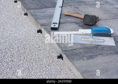 Professionelle Installation von Terrassenplatten mit Abstandshaltern und Werkzeugen Stockfoto